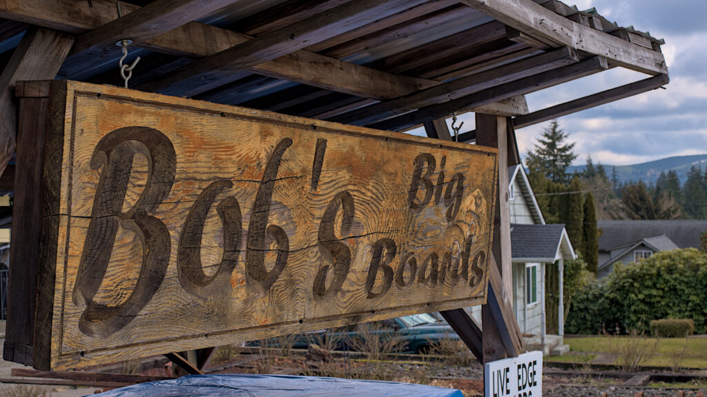 Bob’s Big Boards backyard sawmill in Longview, Washington, producing custom lumber and handcrafted wood slabs with local timber, artisanal milling equipment, and Pacific Northwest craftsmanship in a rural workshop setting.