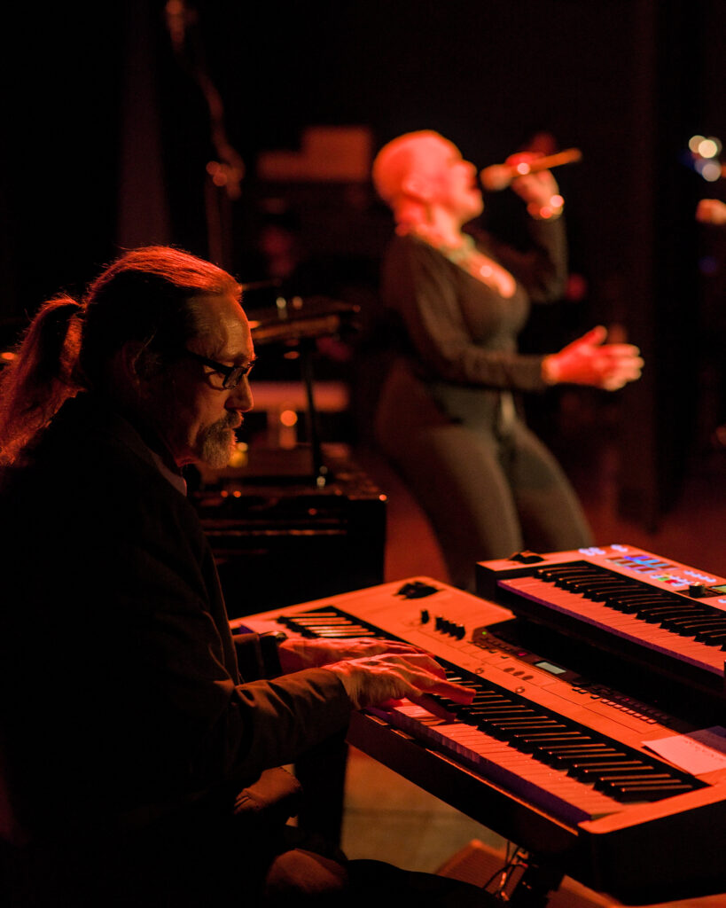 LaRhonda Steele performing live soul, blues, and jazz music on stage at the historic Columbia Theatre in Longview, Washington, during the venue’s centennial celebration with band and community choir.