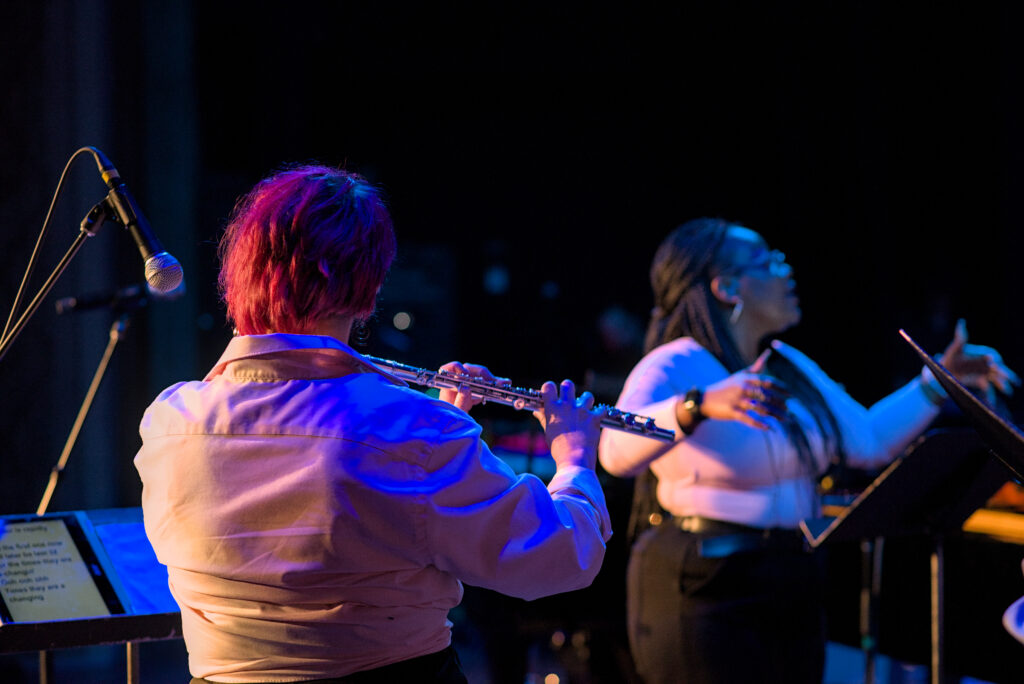 LaRhonda Steele performing live soul, blues, and jazz music on stage at the historic Columbia Theatre in Longview, Washington, during the venue’s centennial celebration with band and community choir.