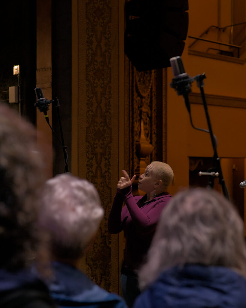 LaRhonda Steele performing live soul, blues, and jazz music on stage at the historic Columbia Theatre in Longview, Washington, during the venue’s centennial celebration with band and community choir.