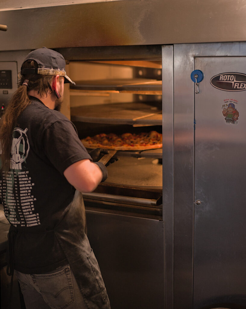 Candid photos inside the Thirsty Sasquatch and Hungry Sasquatch in Vancouver, Washington, showing pizza, craft beer, bar seating, and arcade games in a lively local restaurant and pub setting.