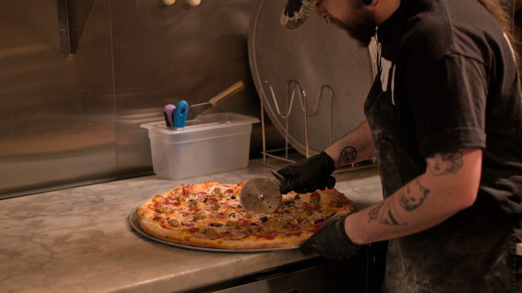 Candid photos inside the Thirsty Sasquatch and Hungry Sasquatch in Vancouver, Washington, showing pizza, craft beer, bar seating, and arcade games in a lively local restaurant and pub setting. Thirsty Sasquatch / Hungry Sasquatch