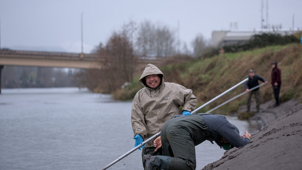 Anglers standing along the Cowlitz River in Longview during the 2025 smelt run attempting dip-net fishing, with no catches and visible turnout despite criticism of WDFW’s timing and management.